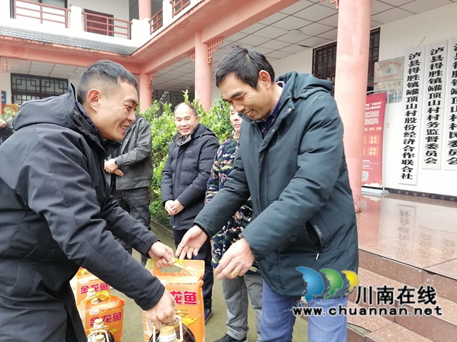 瀘縣農(nóng)民工服務(wù)中心副主任（左一）為返鄉(xiāng)農(nóng)民工代表送上暖心慰問(wèn)物品.jpg